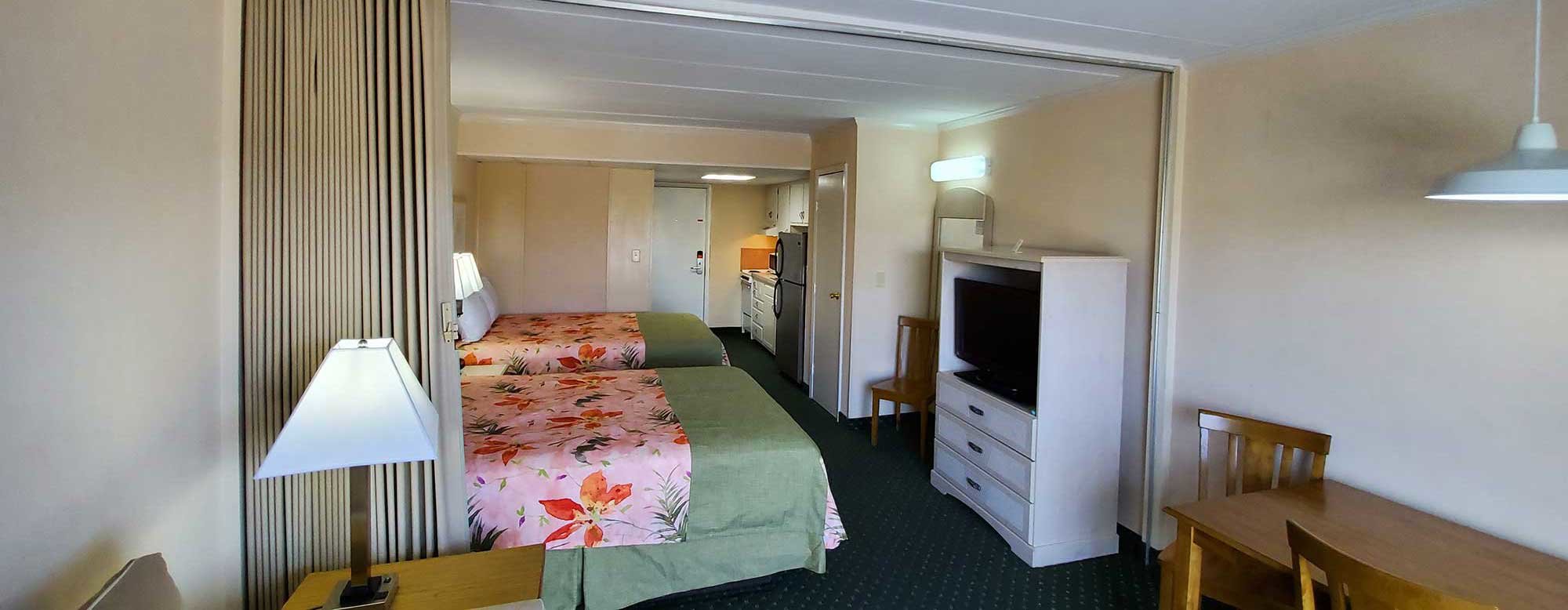 Efficiency Room at the Sea Hawk Motel with two queen beds, TV, table and kitchen